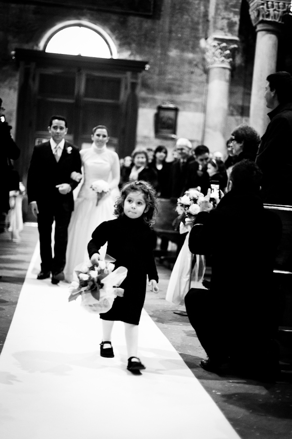 Flower girl walking down the aisle with the bride and the bride's